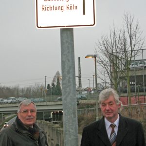 SPD-Ratsvertreter Volkmar Bromby und Hans-R. Müller am neuen Hinweisschild
