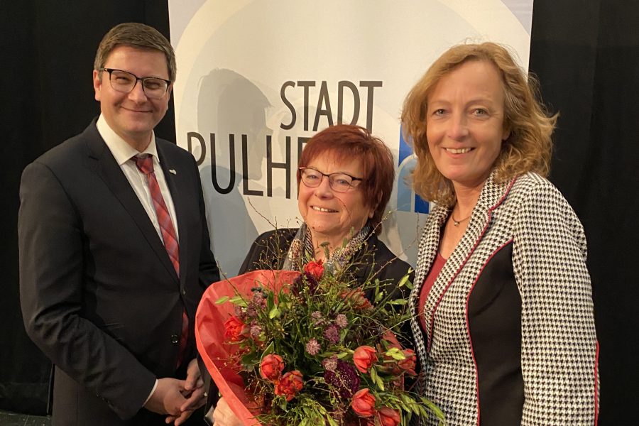 Torsten Rekewitz und Sylvia Fröhling gratulieren Marlies Stroschein mit einem Blumenstrauß