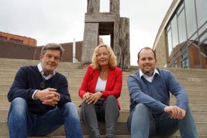 Vetter, Fröhling und Hochhausen auf der Treppe vor dem Medienzentrum sitzend